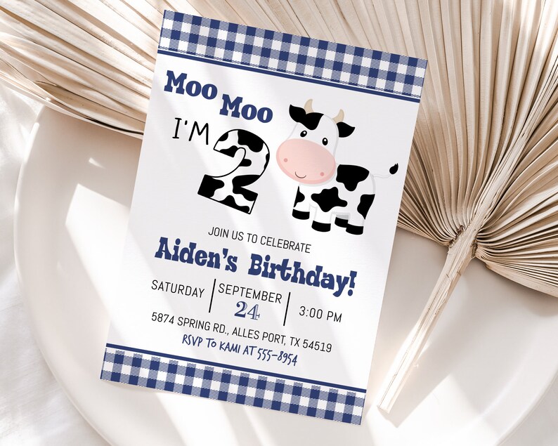 K&ouml;nnte beinhalten: Eine Einladung mit blau-wei&szlig;em Karomuster mit einer Comic-Kuh und dem Text "Moo Moo I'm 2" und "Aiden's Birthday!"  Feiern Sie mit uns am Samstag, den 24. September um 15:00 Uhr. 5874 Spring Rd., Alles Port, TX 54519. RSVP an Kami unter 555-8954.
