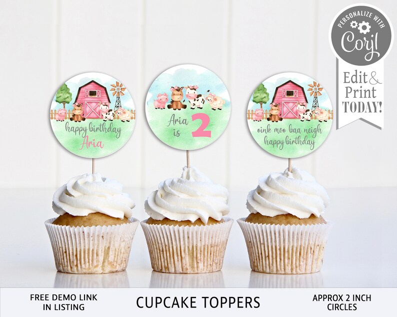 May include: Three round cupcake toppers featuring a farm theme with a pink barn, animals, and green grass. The toppers say "happy birthday Aria", "Aria is 2", and "oink mee baa neigh happy birthday".