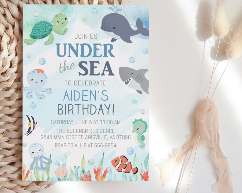 May include: Under the Sea themed birthday party invitation with a blue watercolor background. The invitation features cartoon sea creatures like a turtle, whale, octopus, shark, seahorse, and a clownfish. The text reads "Join us Under the Sea to celebrate Aiden's Birthday! Saturday, June 5 at 11:30 AM The Buckner Residence 2545 Main Street, Anisville, VA 87856 RSVP to Allie at 555-9854"