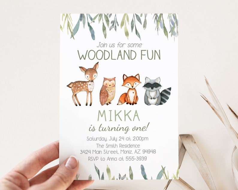 May include: A woodland-themed invitation with watercolor illustrations of a deer, owl, fox, and raccoon. The text reads "Join us for some WOODLAND FUN" and "MIKKA is turning one!" Additional details include the date, time, and RSVP information.