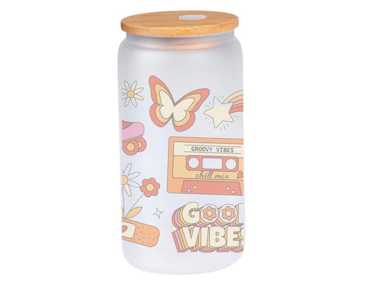 May include: A frosted glass jar with a wooden lid. The jar has a retro design with a butterfly, a cassette tape, a roller skate, and the text "Groovy Vibes" and "Good Vibes".
