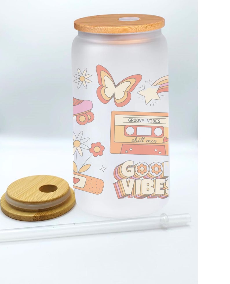 May include: A frosted glass water bottle with a bamboo lid and straw. The bottle has a retro design with a butterfly, roller skates, a cassette tape, and the text "Groovy Vibes chill mix" and "Good Vibes".