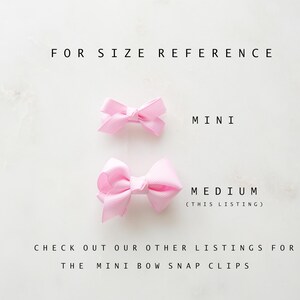 May include: Two light pink hair bows are displayed against a white background for size reference. The top bow is labeled "MINI", and the bottom bow is labeled "MEDIUM (THIS LISTING)". Text at the bottom reads "CHECK OUT OUR OTHER LISTINGS FOR THE MINI BOW SNAP CLIPS."