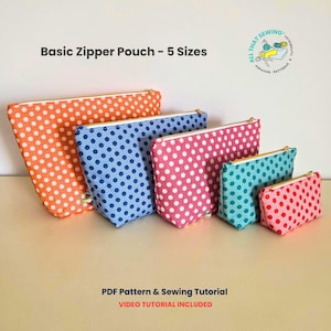 May include: Five polka dot zipper pouches in different sizes and colours: orange, blue, pink, teal, and red. Each pouch has white spots and gold zips. The image includes text that reads "Basic Zipper Pouch - 5 Sizes".