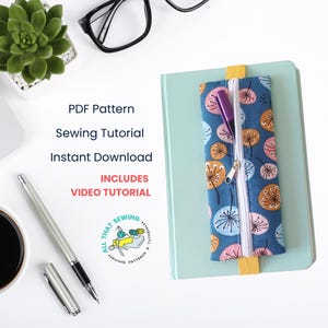 May include: A blue pencil case with a zipper and a dandelion print. The case is on a light blue notebook. The text "PDF Pattern Sewing Tutorial Instant Download Includes Video Tutorial" is on a white background. The text "All That Sewing" is in a circle with a sewing machine and thread.