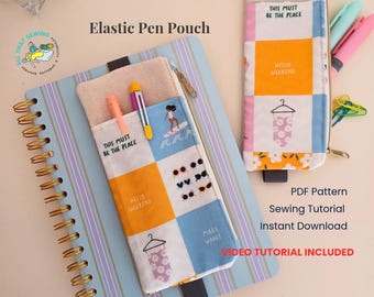 May include: Two fabric pen pouches with elastic bands, featuring a grid pattern of yellow, blue, and white squares with illustrations of sunglasses, a swimsuit on a hanger, and text reading This Must Be The Place and Hello Weekend.