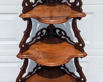 May include: A dark wood corner shelf unit with intricate carvings and four shelves. The shelf unit is freestanding and has a traditional design.