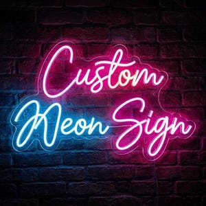 May include: A custom neon sign mounted on a dark brick wall. The sign features the words Custom Neon Sign in a cursive script font. The word Custom is illuminated in bright pink, while the words Neon Sign are in a mix of blue and pink light.