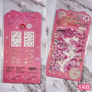 Pu&ograve; includere: Due fogli di adesivi rosa con disegni di fiori di ciliegio. Un foglio ha pi&ugrave; disegni di adesivi, e l'altro ha una grande composizione floreale. Gli adesivi sono confezionati in una custodia di plastica trasparente.