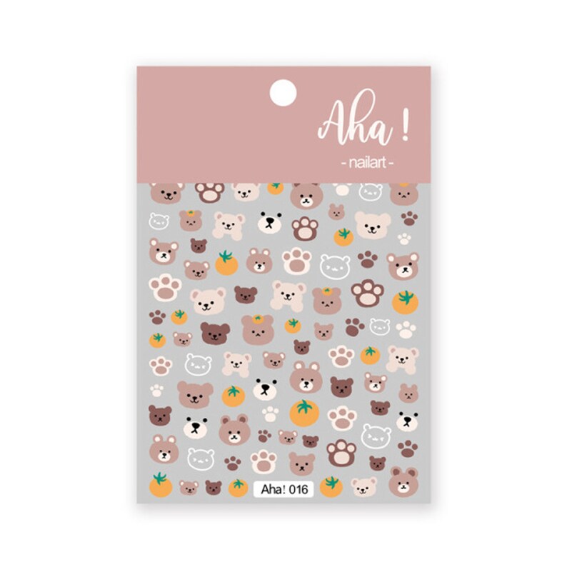 May include: Sheet of nail art stickers featuring a repeating pattern of cartoon bears, paw prints, and small orange fruits. The stickers are in shades of brown, tan, and white on a gray background. The text "Aha! nailart" is at the top.