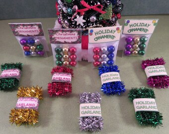 May include: Miniature Christmas ornaments in clear plastic bags with labels reading Christmas Ornaments or Holiday Ornaments, and rolls of tinsel garland with labels reading Christmas Garland or Holiday Garland in various metallic colours.