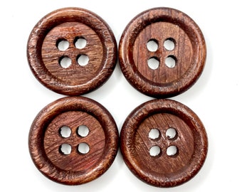 May include: Four brown wooden buttons with four holes each. The buttons are arranged in a square pattern.