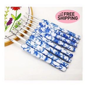 Puede incluir: Conjunto de 10 agujas de crochet con mangos con estampado floral azul y blanco. Las agujas son de metal y tienen varios tamaños.