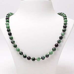 May include: A green and black gemstone bead necklace. The beads are round and have a smooth, polished finish.
