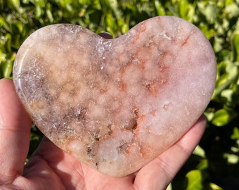 May include: A heart-shaped pink and white crystal with red veins. The crystal is smooth and polished.