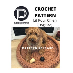 Könnte beinhalten: Ein gehäkeltes Hundebett in brauner Farbe mit einem Hund, der darin sitzt. Das Bett ist aus dickem Garn gefertigt und hat eine runde Form. Der Text "PATTERN RELEASE" ist auf dem Bett geschrieben. Der Text "@dezignsbydyan" ist in der oberen linken Ecke des Bildes geschrieben. Der Text "CROCHET PATTERN Lit Pour Chien (Dog Bed)" ist in der oberen Mitte des Bildes geschrieben.
