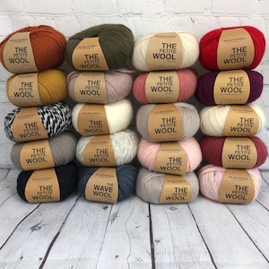 May include: A collection of 18 balls of yarn in various colours, including red, pink, yellow, green, white, black, and grey. Each ball has a label that reads "The Petite Wool" or "The Wave Wool".