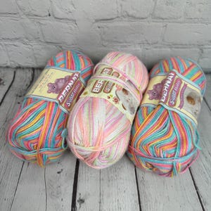 May include: Three skeins of Bernat Softee Baby yarn in a rainbow colorway. The yarn is a soft, fluffy, and lightweight acrylic yarn that is perfect for baby blankets, sweaters, and other projects.