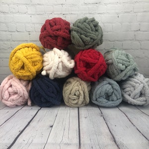 May include: Ten balls of yarn in various colours, including pink, blue, beige, white, yellow, red, and green. The yarn is soft and fluffy, perfect for crocheting or knitting.