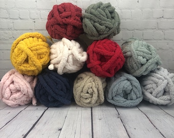 May include: Ten balls of yarn in various colors, including pink, blue, beige, white, yellow, red, and green. The yarn is soft and fluffy, perfect for crocheting or knitting.