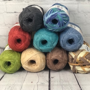 Peut inclure: Assortiment de dix pelotes de laine de différentes couleurs, notamment turquoise, bleu, rouge, vert, marron et beige. La laine est fabriquée à partir de papier recyclé et est parfaite pour le bricolage.