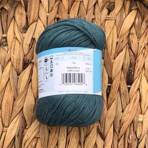 Op de afbeelding: Een bol tealblauwe garen met het label "Dragonfly Libellule", een barcode en de tekst "Made in Turkey | Fabriqu&eacute; en Turquie".
