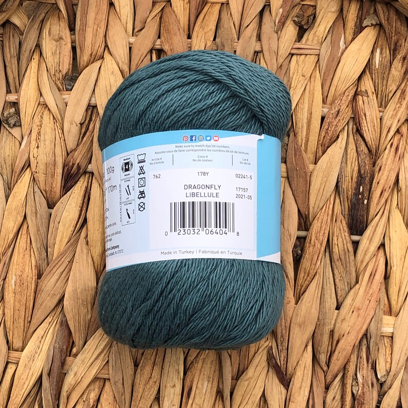 Op de afbeelding: Een bol tealblauwe garen met het label "Dragonfly Libellule", een barcode en de tekst "Made in Turkey | Fabriqu&eacute; en Turquie".