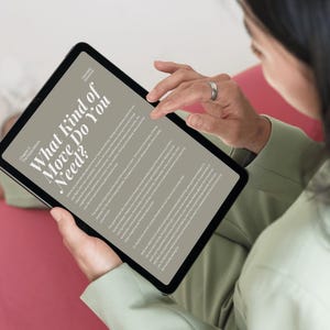 May include: A black tablet displaying a page with the title What Kind of Move Do You Need? and Chapter 2 The Expectations. The screen shows multiple paragraphs of text in a serif font against a light beige background, held by a person in a sage green shirt.
