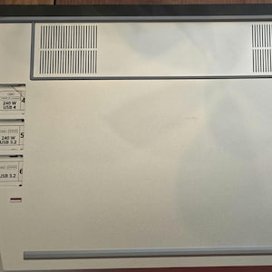 May include: A silver computer with a white front panel and multiple USB ports labelled with "240 W" and "USB 3.2" or "USB 4".