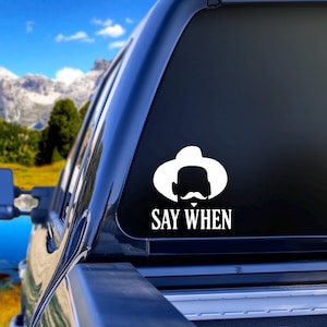 May include: A white vinyl decal with a silhouette of a person wearing a cowboy hat and a mustache. The text "SAY WHEN" is below the silhouette.