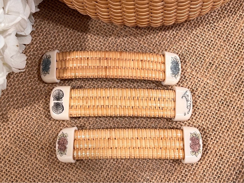 May include: Three woven wicker handles with decorative ceramic ends. The ends feature floral and seashell designs in shades of blue, white, and pink.