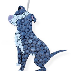 May include: A black and white pit bull dog ornament made of painted circles. The dog is sitting with its tail curled behind it. The ornament has a string for hanging.