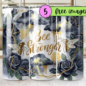 May include: A white tumbler with a design featuring bees, dark blue roses, and storm clouds with gold accents. The words "Bee Stronger" are in gold script. The tumbler also has the text "5 free images".