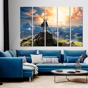 Puede incluir: Una impresi&oacute;n en lienzo de varios paneles que representa a un personaje de videojuego de pie en la cima de una monta&ntilde;a con vistas a un vasto paisaje. El personaje lleva una t&uacute;nica verde y sostiene una espada. El cielo es de un naranja y amarillo vibrantes, con nubes y p&aacute;jaros volando por encima.