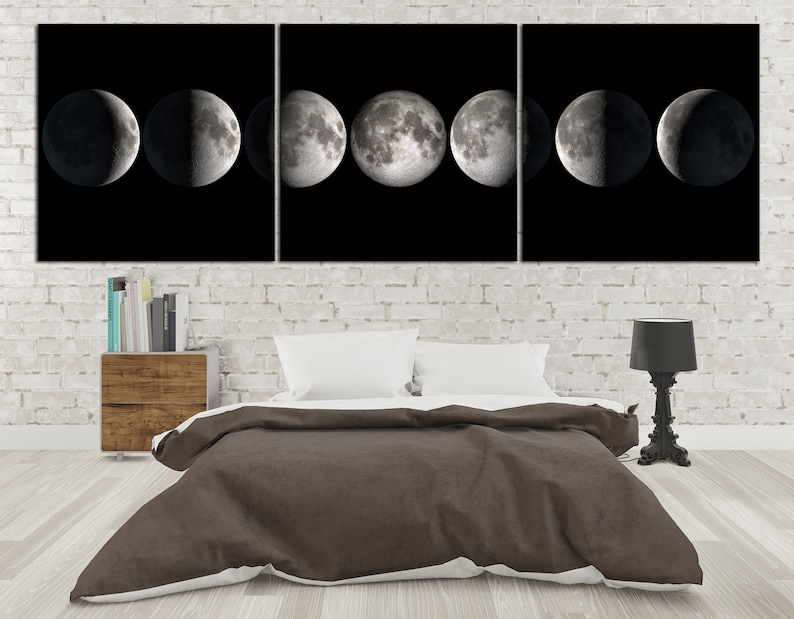 May include: A black and white triptych canvas wall art featuring a series of moon phases. The canvas is displayed above a brown duvet cover on a bed with white pillows.