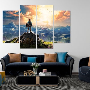 Puede incluir: Una impresi&oacute;n en lienzo de varios paneles que presenta un personaje de videojuego de pie en un acantilado rocoso con vistas a un vasto paisaje monta&ntilde;oso. El cielo es de un naranja y amarillo vibrantes, con nubes y p&aacute;jaros volando por encima.