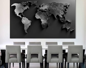May include: A large, black and white world map art piece mounted on a wall above a white dining table. The map has a textured appearance, with continents in varying shades of gray. Gray chairs with black legs are arranged around the table, creating a modern dining room setting.