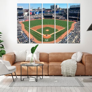 May include: A panoramic view of a baseball field with green grass and a brown dirt infield. The field is surrounded by a large crowd of people in the stands. The stands are filled with people wearing blue and white clothing. The field is surrounded by a large stadium with a scoreboard in the background. The scoreboard displays the text "A DELTA".