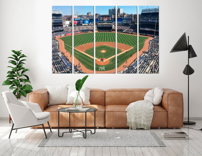 May include: A panoramic view of a baseball field with green grass and a brown dirt infield. The field is surrounded by a large crowd of people in the stands. The stands are filled with people wearing blue and white clothing. The field is surrounded by a large stadium with a scoreboard in the background. The scoreboard displays the text "A DELTA".