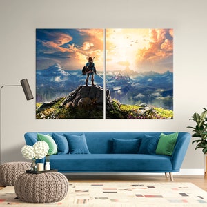 Puede incluir: Una impresi&oacute;n en lienzo dividida que presenta un personaje de videojuego de pie en la cima de una monta&ntilde;a con vistas a un vasto paisaje. El personaje lleva una t&uacute;nica azul y sostiene una espada. El cielo es de un naranja y rosa vibrantes, con nubes y un sol brillante en la distancia.