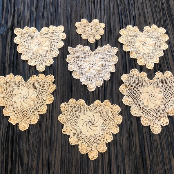 Heart-shaped crocheted vintage doilies with pinwheel center pattern, scalloped edges with flowers in each scallop set of seven, three sizes