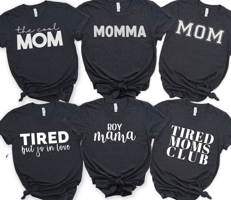 May include: Six dark grey t-shirts with white text. The shirts read "the cool MOM", "MOMMA", "MOM", "TIRED but so in love", "BOY mama", and "TIRED MOMS CLUB".