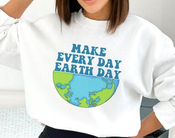 Puede incluir: Sudadera blanca con un gráfico azul y verde de la Tierra y el texto "Make Every Day Earth Day" en una fuente retro.