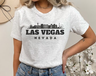 May include: A grey t-shirt with a black graphic of the Las Vegas skyline and the text "LAS VEGAS NEVADA".