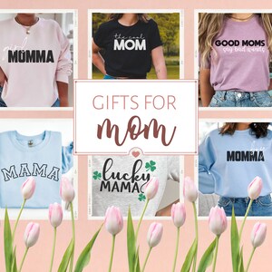 May include: A collage of five different t-shirts with various designs and text related to mothers. The text on the shirts includes "Girl Momma", "The Cool Mom", "Good Moms Say Bad Words", "Mama", and "Lucky Mama". The shirts are displayed on a pink background with pink tulips.