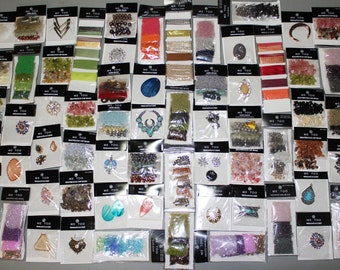 May include: A collection of over 50 small bags of assorted beads, charms, and embellishments. The bags are labeled "Me Too" and contain a variety of colors, shapes, and sizes.