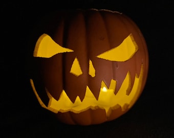 Puede incluir: Una calabaza marrón tallada con una cara amenazante, iluminada desde dentro por una cálida luz amarilla. La calabaza tiene ojos triangulares, una boca dentada y una superficie texturizada, creando una decoración de Halloween.