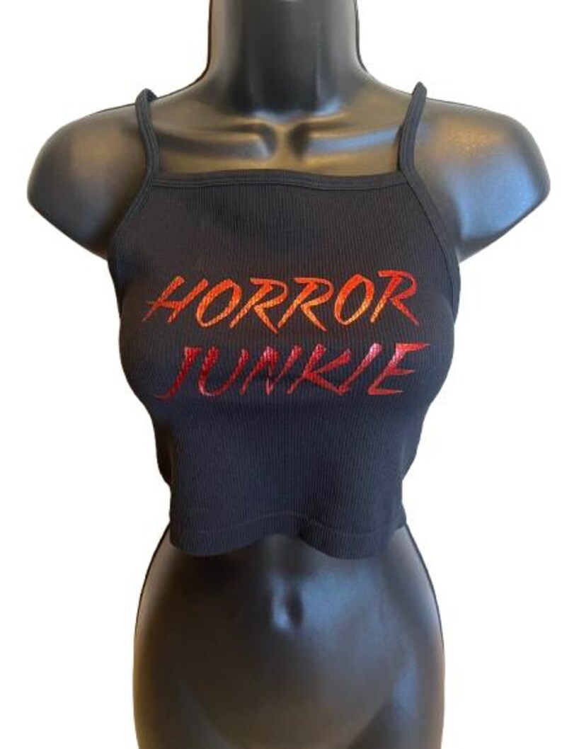 May include: Black crop top with red and orange "HORROR JUNKIE" text printed on the front.