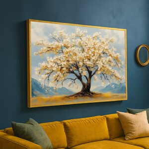 以下が含まれることがあります： 白い花と茶色の幹を持つ、咲き誇る木の額入り絵画。 このアートワークは金色のフレームで、山と薄い青い空のある風景を描いています。 絵画は濃い青色の壁に飾られています。
