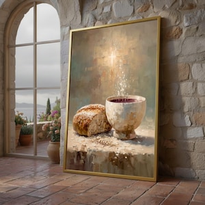 Puede incluir: Pintura enmarcada que representa una naturaleza muerta con un pan y un cáliz lleno de líquido rojo. La obra de arte tiene una paleta de colores cálidos y un marco dorado. El fondo presenta una cruz y una luz suave y borrosa.